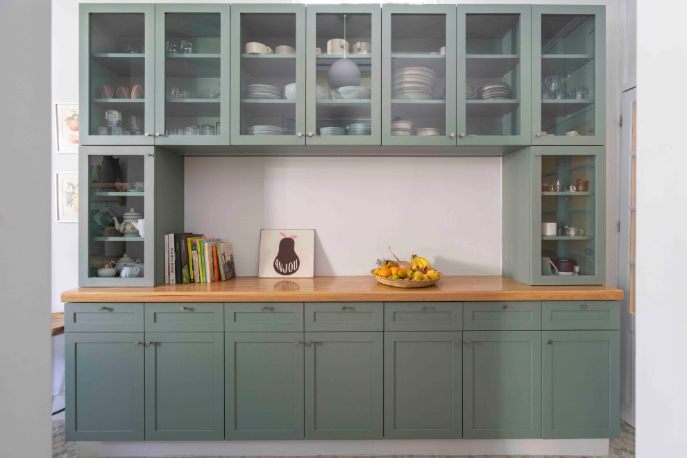 Photo of a small traditional single-wall kitchen pantry in Mexico City with a double-bowl sink, glass-front cabinets, green cabinets, wood benchtops, green splashback, ceramic splashback, stainless steel appliances, cement tiles, no island, green floor and recessed.