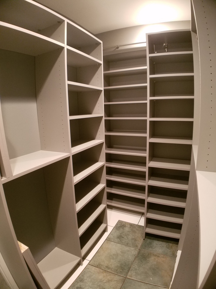 This is an example of a small gender-neutral walk-in wardrobe in Orange County with grey cabinets, ceramic floors and green floor.