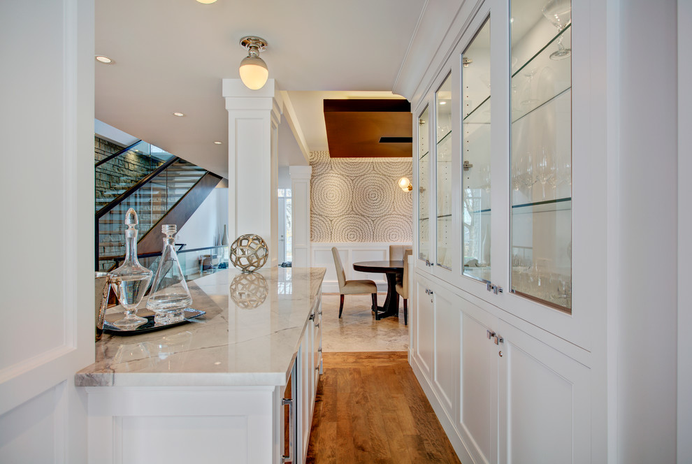 Inspiration for a transitional galley light wood floor eat-in kitchen remodel in Calgary with white walls, shaker cabinets, white cabinets, marble countertops and stainless steel appliances