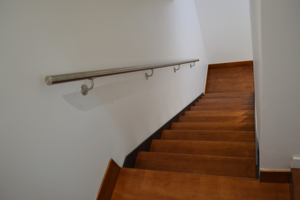 Photo of a large contemporary wood floating staircase in San Diego with open risers.