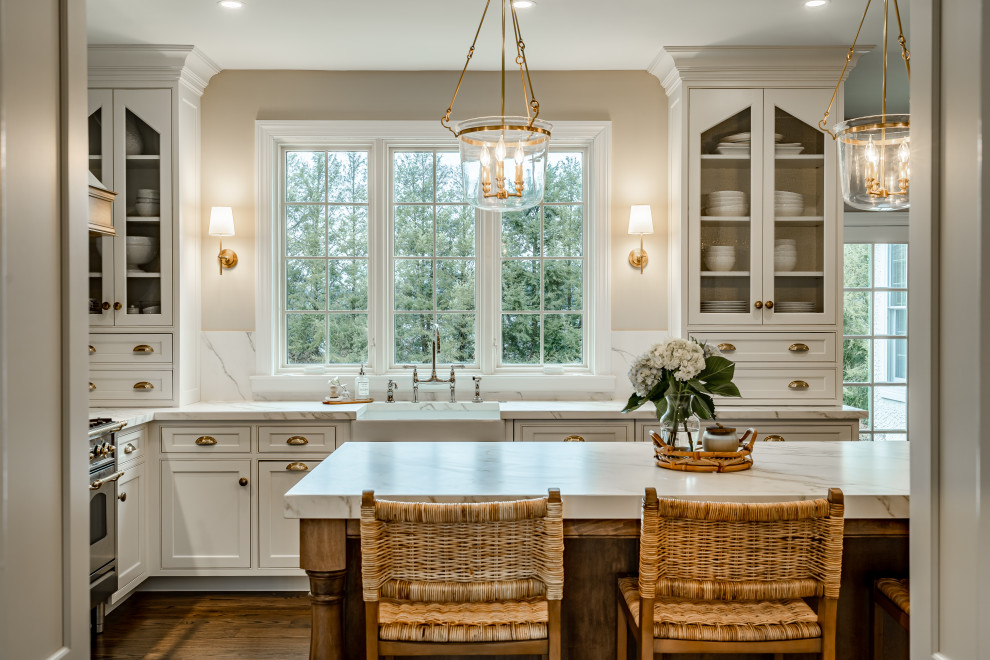 Large farmhouse u-shaped medium tone wood floor and brown floor enclosed kitchen photo in Philadelphia with a farmhouse sink, beaded inset cabinets, white cabinets, multicolored backsplash, mosaic tile backsplash, paneled appliances, an island and white countertops