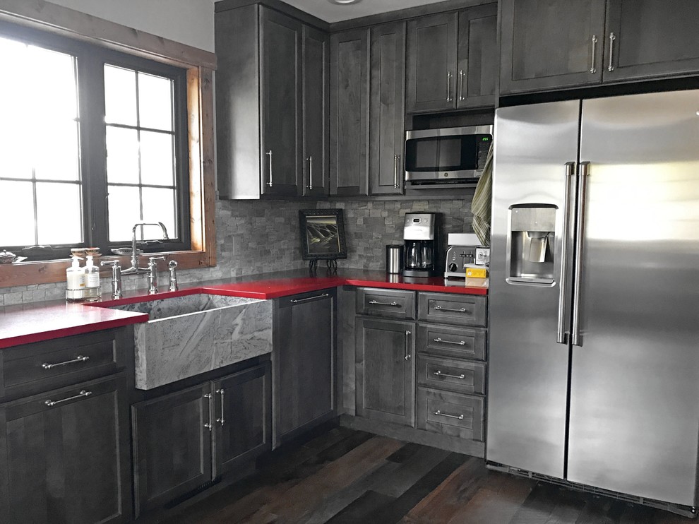 Inspiration for a mid-sized transitional l-shaped eat-in kitchen in Denver with a farmhouse sink, shaker cabinets, grey cabinets, quartz benchtops, grey splashback, stainless steel appliances, dark hardwood floors, no island and red benchtop.