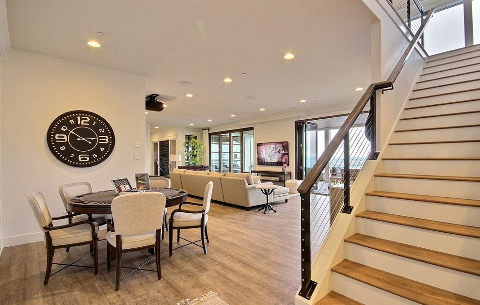 This is an example of an expansive country walk-out basement in Portland with beige walls, medium hardwood floors, no fireplace and brown floor.