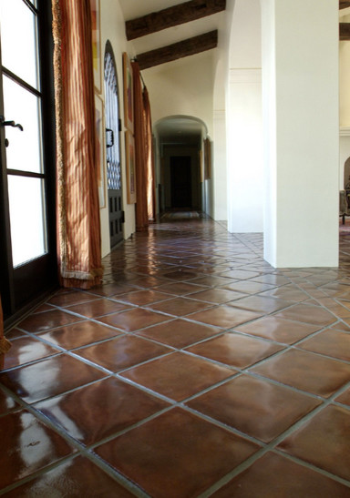 Photo of a mid-sized mediterranean hallway in Los Angeles with beige walls and terra-cotta floors.