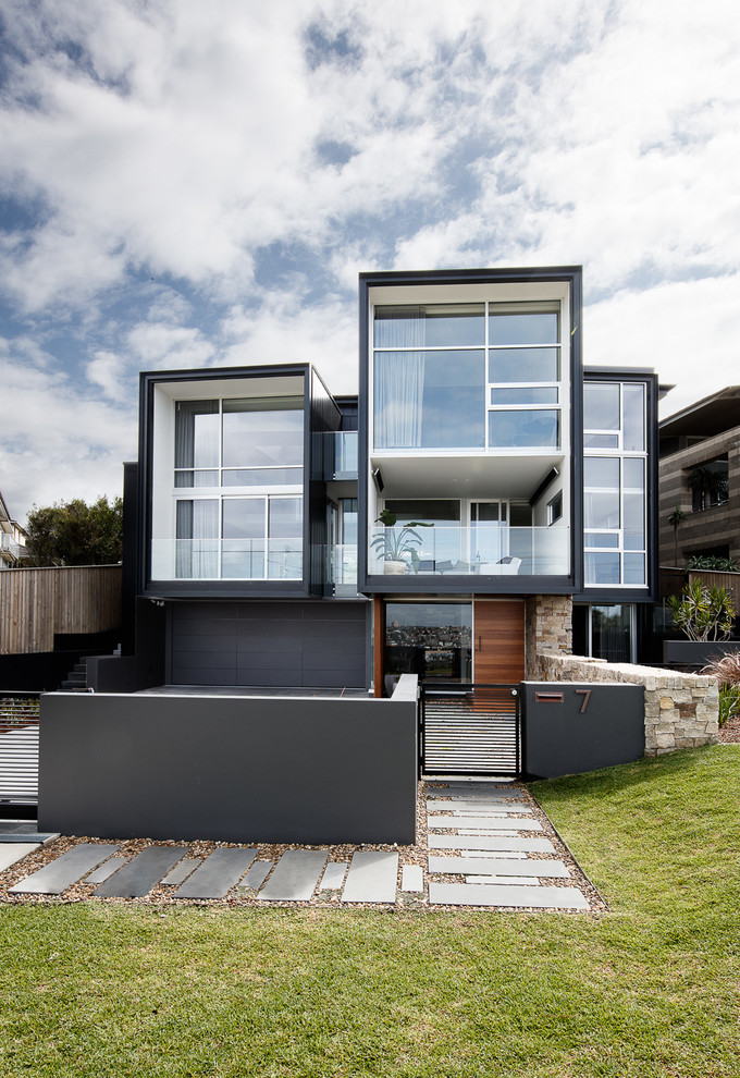 Contemporary three-storey black house exterior in Sydney with a flat roof.