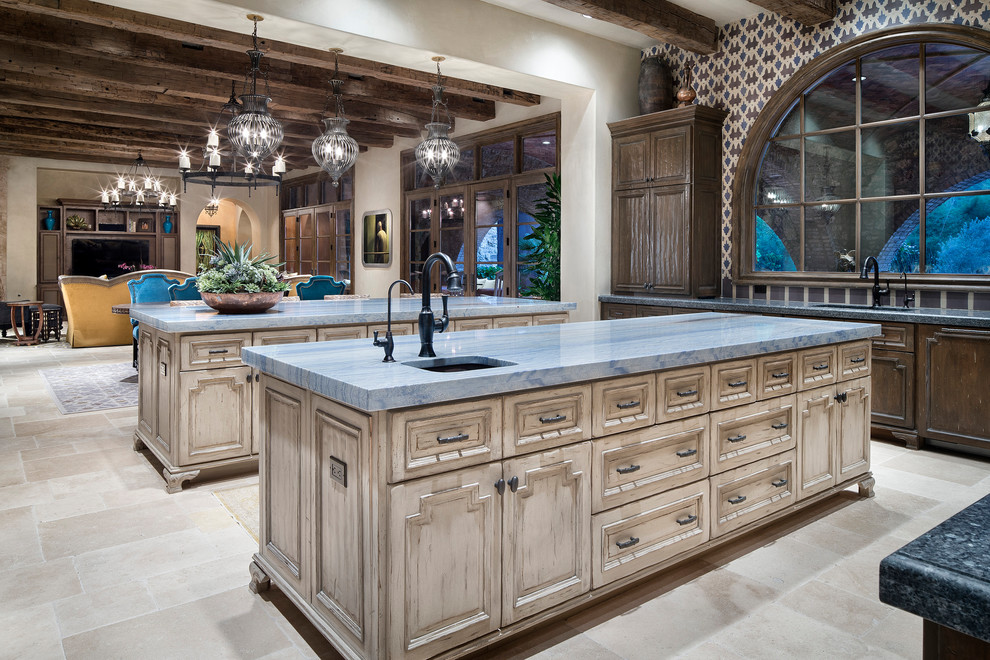 Photo of an expansive mediterranean open plan kitchen in Houston with an undermount sink, recessed-panel cabinets, medium wood cabinets, multi-coloured splashback, mosaic tile splashback, coloured appliances, marble floors, multiple islands, beige floor and blue benchtop.