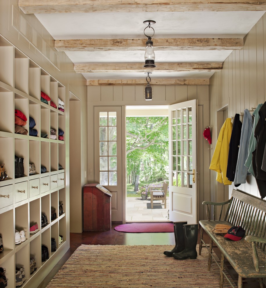 Example of a large cottage medium tone wood floor mudroom design in New York with gray walls and a white front door