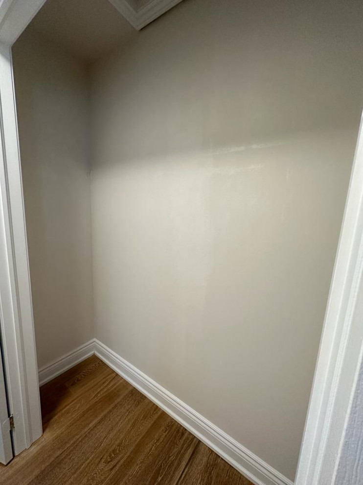 Immagine di un armadio o armadio a muro unisex chic di medie dimensioni con ante bianche, parquet chiaro e pavimento beige