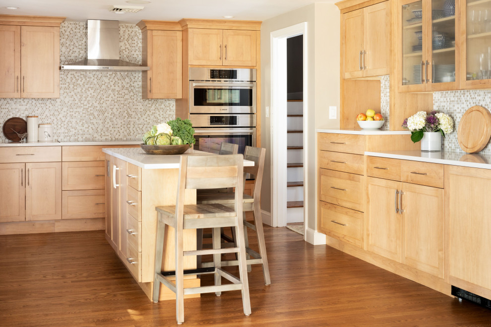 Example of a transitional medium tone wood floor enclosed kitchen design in Boston with shaker cabinets, light wood cabinets, multicolored backsplash, mosaic tile backsplash, an island and white countertops
