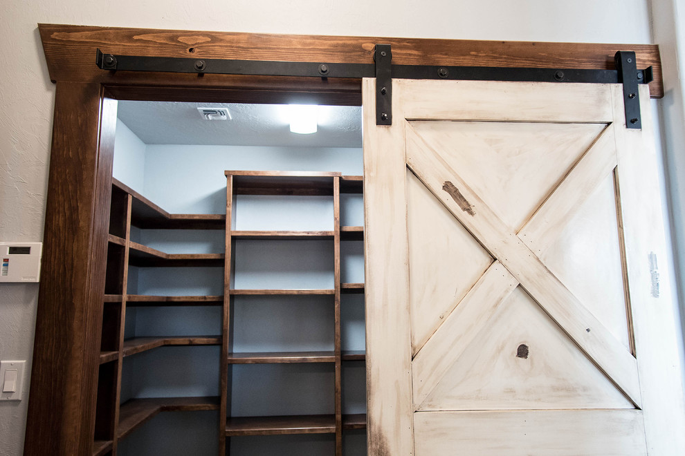 Inspiration for a mid-sized country gender-neutral walk-in wardrobe in Oklahoma City with open cabinets, dark wood cabinets and dark hardwood floors.
