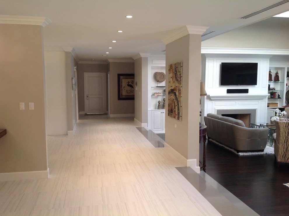 This is an example of a large transitional hallway in Miami with beige walls and porcelain floors.