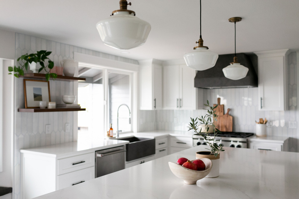 Design ideas for a large contemporary l-shaped open plan kitchen in Portland with a farmhouse sink, shaker cabinets, white cabinets, quartzite benchtops, white splashback, marble splashback, stainless steel appliances, laminate floors, with island, brown floor and white benchtop.