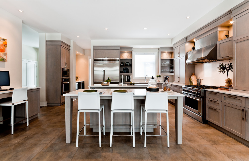 This is an example of a traditional kitchen in Montreal with stainless steel appliances and brown floor.