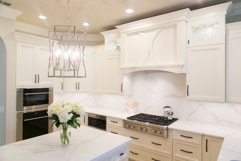 Open concept kitchen - mid-sized transitional u-shaped open concept kitchen idea in Orlando with an undermount sink, recessed-panel cabinets, white cabinets, quartzite countertops, white backsplash, stone slab backsplash, stainless steel appliances and a peninsula