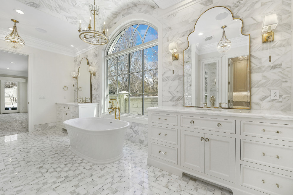 Inspiration for an expansive master bathroom in Salt Lake City with recessed-panel cabinets, white cabinets, a freestanding tub, an open shower, a one-piece toilet, gray tile, marble, white walls, marble floors, an undermount sink, marble benchtops, grey floor, a hinged shower door, white benchtops, a laundry, a double vanity and a built-in vanity.