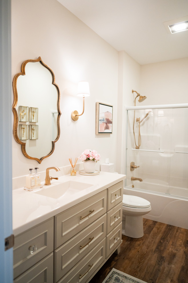 Inspiration for a mid-sized contemporary master bathroom in Cedar Rapids with shaker cabinets, a corner tub, a shower/bathtub combo, a one-piece toilet, medium hardwood floors, engineered quartz benchtops, a single vanity, a built-in vanity, brown floor, an integrated sink, yellow cabinets and yellow benchtops.