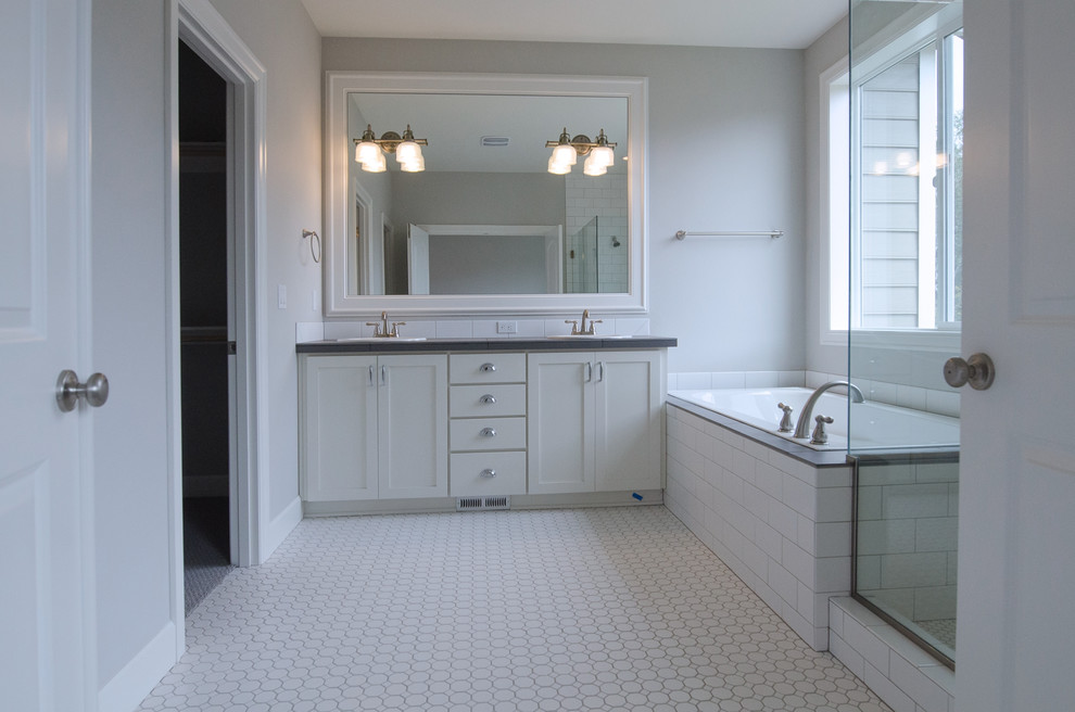 Large transitional master bathroom in Portland with an undermount sink, shaker cabinets, white cabinets, tile benchtops, a drop-in tub, a corner shower, a one-piece toilet, white tile, ceramic tile, grey walls and ceramic floors.