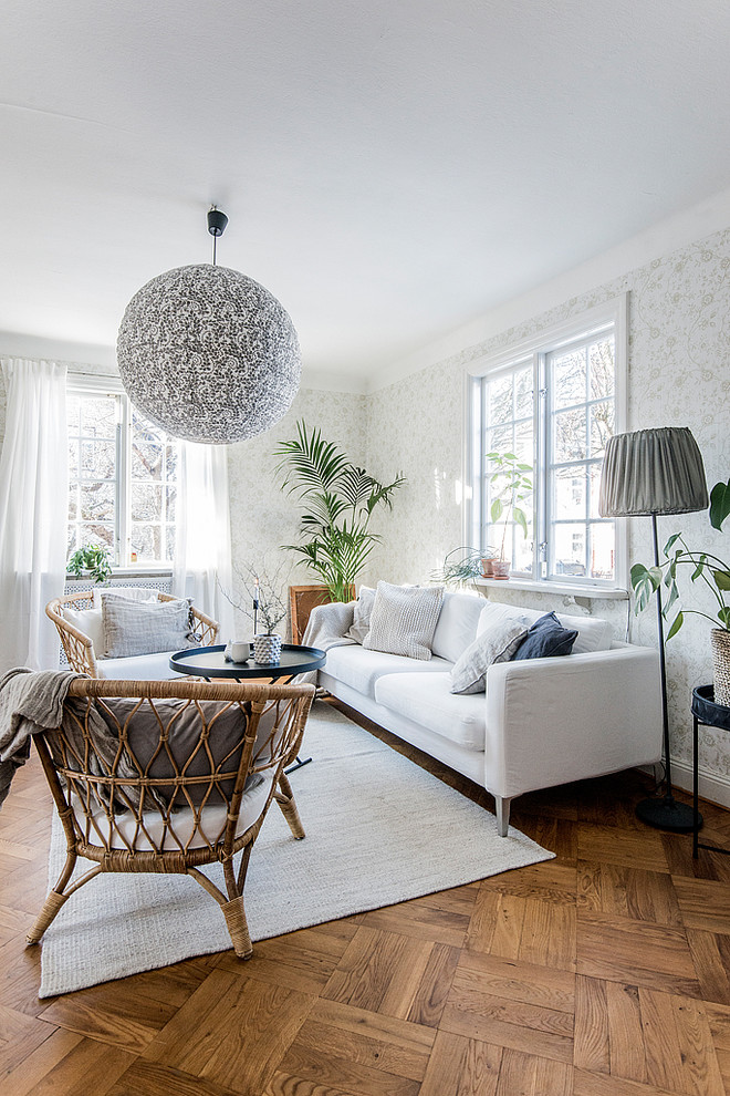 Inspiration for a mid-sized scandinavian formal enclosed living room in Stockholm with multi-coloured walls, medium hardwood floors and brown floor.