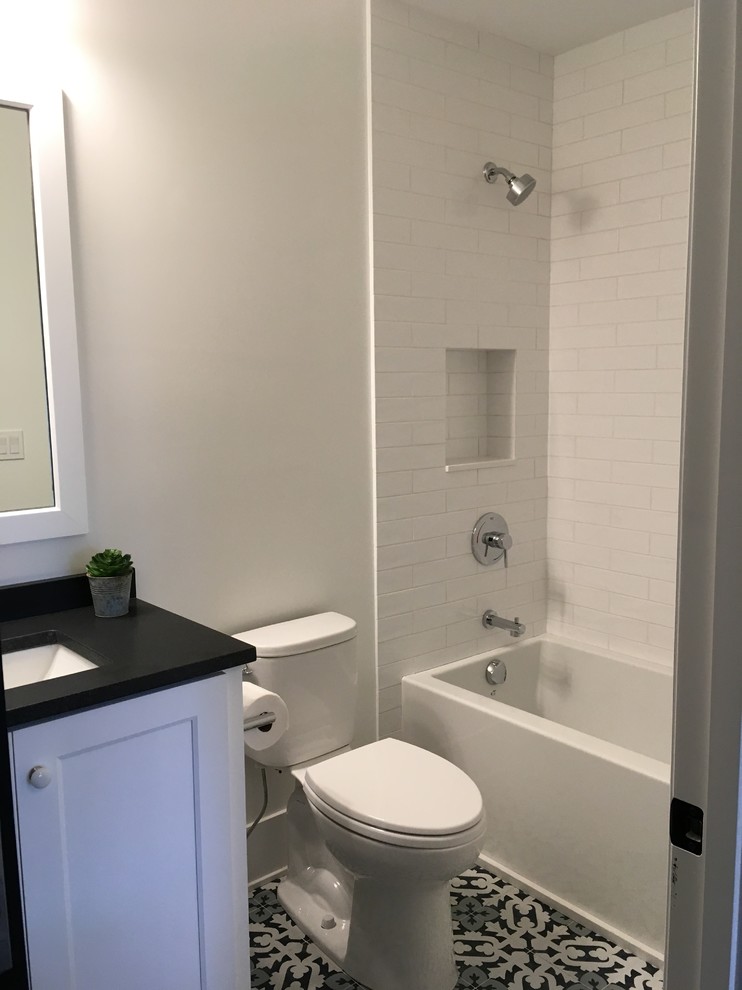 Inspiration for a mid-sized transitional kids' white tile and ceramic tile porcelain tile and multicolored floor alcove bathtub remodel in Chicago with shaker cabinets, white cabinets, a two-piece toilet, gray walls, an undermount sink, quartz countertops and black countertops