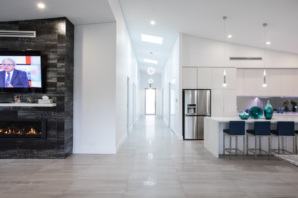 This is an example of a mid-sized modern entry hall in Sydney with white walls, porcelain floors, a glass front door and grey floor.