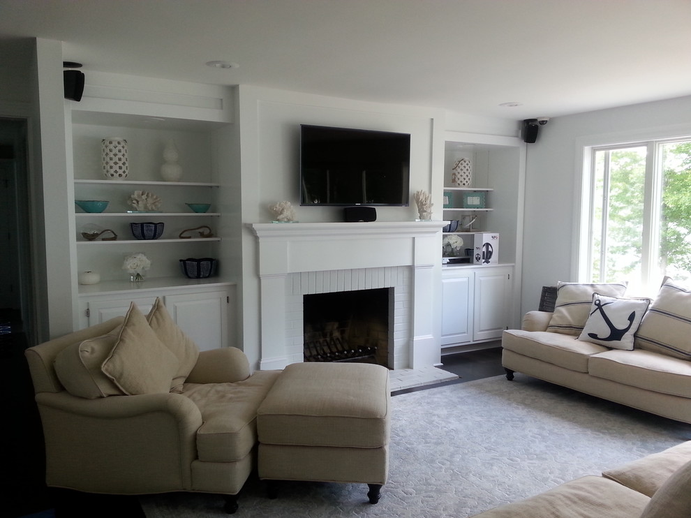 Design ideas for a mid-sized beach style formal open concept living room in Boston with grey walls, carpet, a standard fireplace, a brick fireplace surround and a wall-mounted tv.