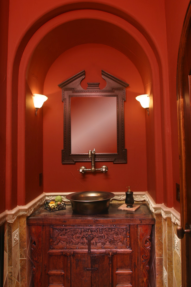 Photo of a small eclectic powder room in Denver with a vessel sink, furniture-like cabinets, medium wood cabinets, wood benchtops, brown tile, red walls and red benchtops.
