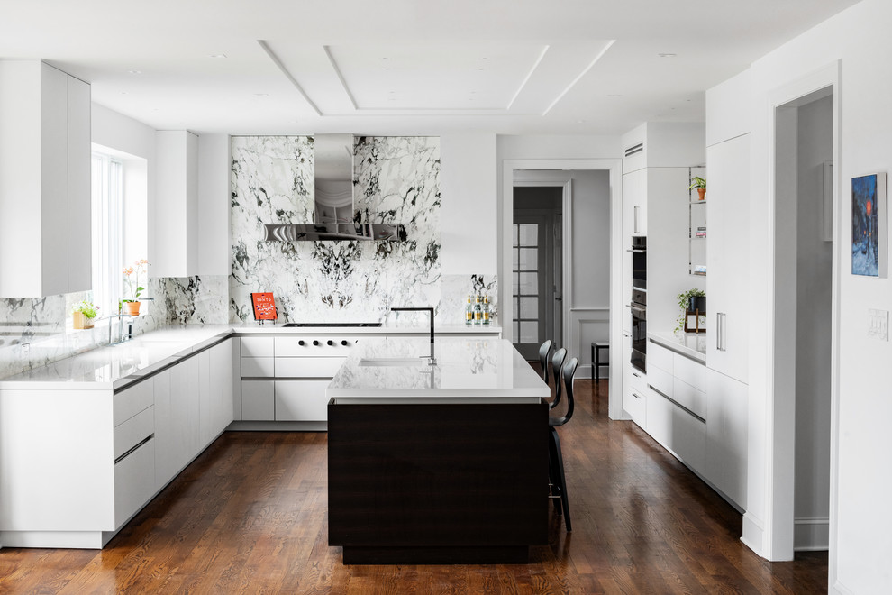Inspiration for a contemporary u-shaped kitchen in Philadelphia with an undermount sink, flat-panel cabinets, white cabinets, multi-coloured splashback, medium hardwood floors, with island, brown floor and white benchtop.