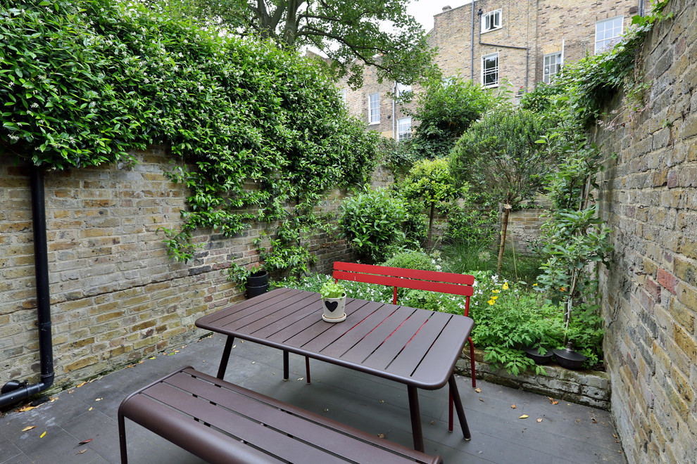 This is an example of a mid-sized industrial backyard deck in Paris with a container garden and no cover.