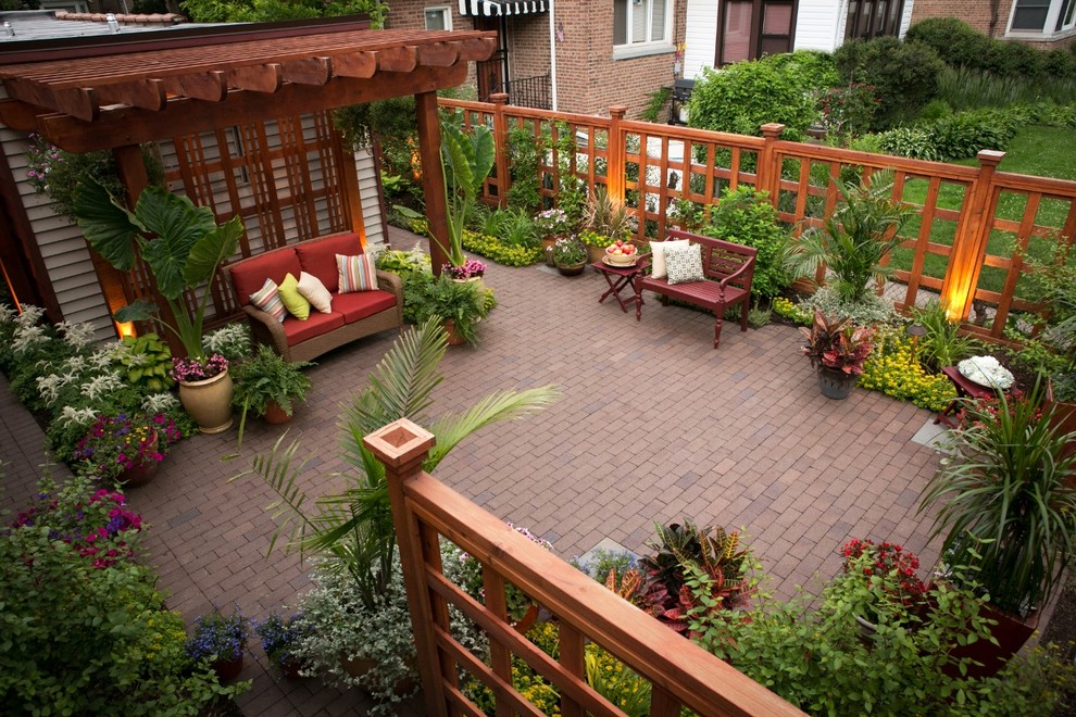 This is an example of a small traditional backyard patio in Chicago with brick pavers and a pergola.