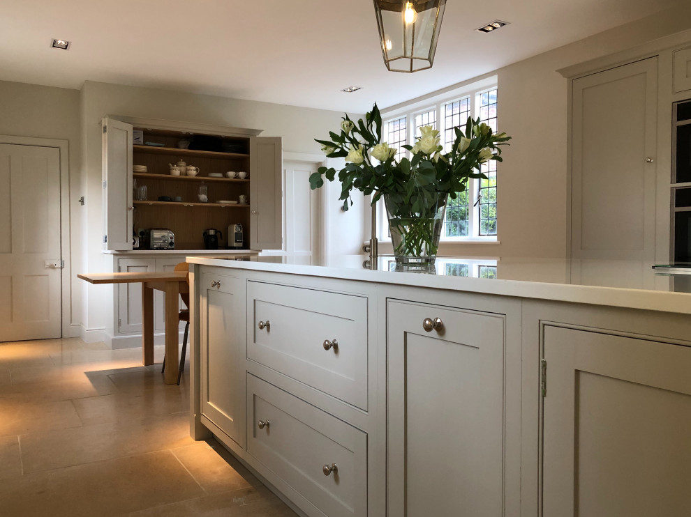 Inspiration for a large traditional single-wall eat-in kitchen in Surrey with a drop-in sink, beaded inset cabinets, grey cabinets, quartzite benchtops, grey splashback, black appliances, with island and white benchtop.