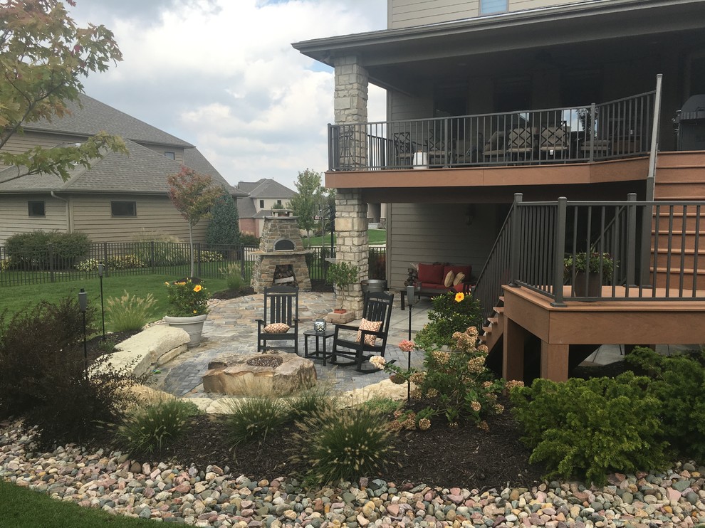 Large modern backyard patio in Omaha with a fire feature and no cover.