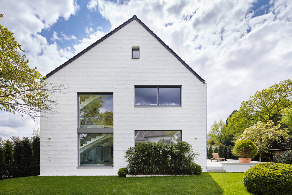 This is an example of a large contemporary three-storey brick white exterior in Dusseldorf.
