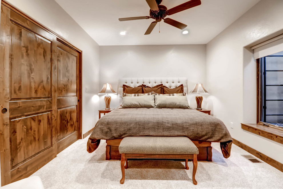 Design ideas for a large transitional guest bedroom in Denver with beige walls and carpet.