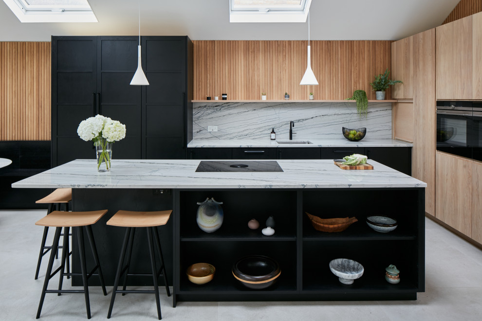 Inspiration for a large scandinavian open plan kitchen in London with a built-in sink, flat-panel cabinets, black cabinets, quartz worktops, multi-coloured splashback, black appliances, an island and multicoloured worktops.