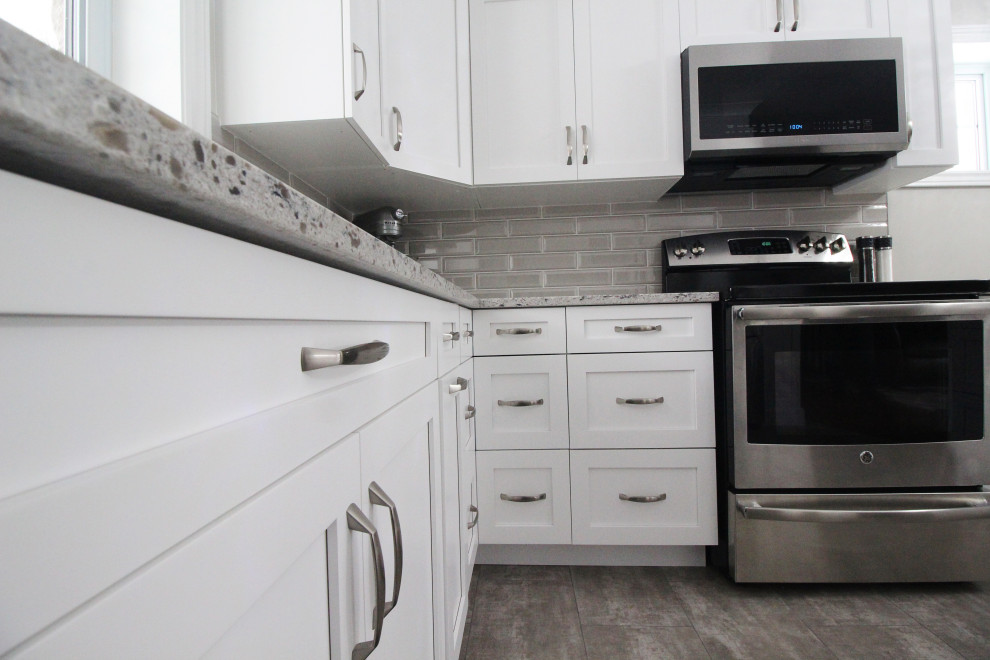 Inspiration for an u-shaped kitchen remodel with shaker cabinets, white cabinets, quartzite countertops, gray backsplash, subway tile backsplash, a peninsula and gray countertops