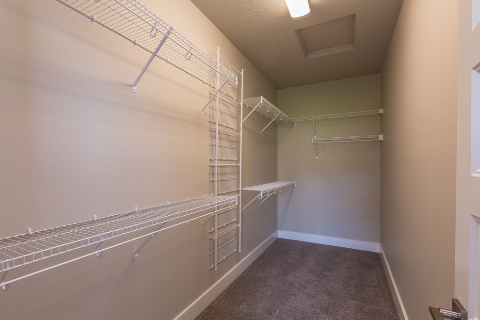 Photo of a mid-sized transitional gender-neutral walk-in wardrobe in Seattle with carpet and grey floor.