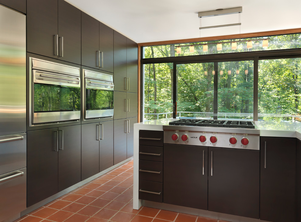 Enclosed kitchen - mid-sized modern l-shaped terra-cotta tile enclosed kitchen idea in Providence with stainless steel appliances, an undermount sink, flat-panel cabinets, dark wood cabinets, quartz countertops and no island