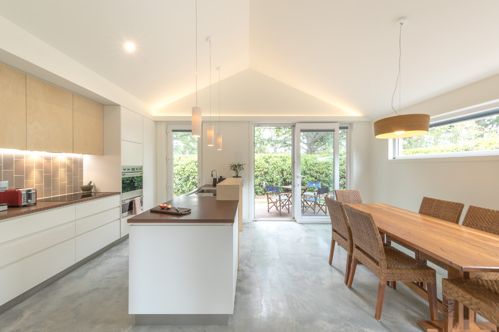Small contemporary open plan dining in Canberra - Queanbeyan with white walls, concrete floors and grey floor.