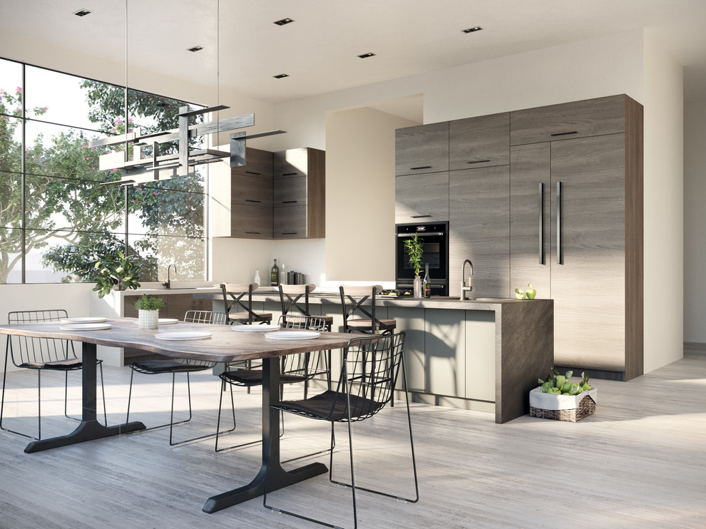 Mid-sized contemporary l-shaped eat-in kitchen in Phoenix with a drop-in sink, flat-panel cabinets, green cabinets, panelled appliances, concrete floors, with island, grey floor and black benchtop.