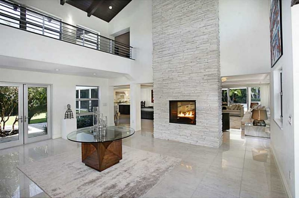 Photo of a large modern entry hall in Miami with white walls, marble floors, a double front door, a glass front door and white floor.