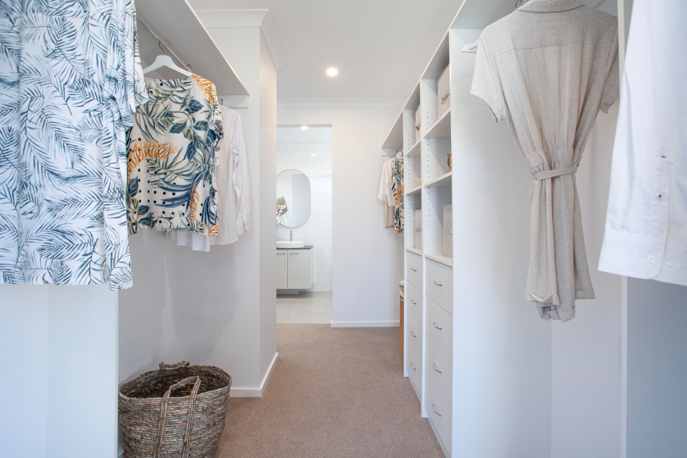 This is an example of a large tropical gender-neutral walk-in wardrobe in Melbourne with carpet and grey floor.