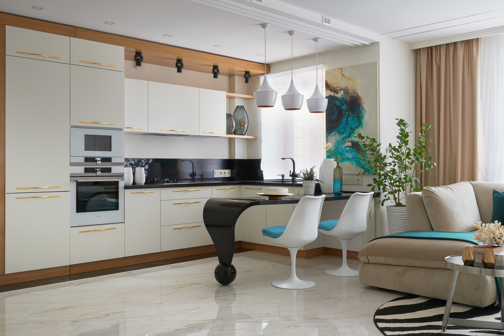 Design ideas for an eclectic l-shaped open plan kitchen in Moscow with flat-panel cabinets, white cabinets, black splashback, white floor, black benchtop, stainless steel appliances and a peninsula.