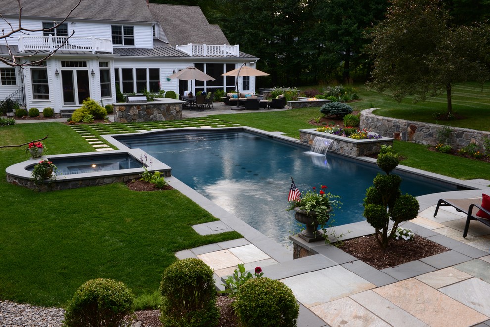 Photo of a mid-sized contemporary backyard rectangular pool in New York with a hot tub and natural stone pavers.