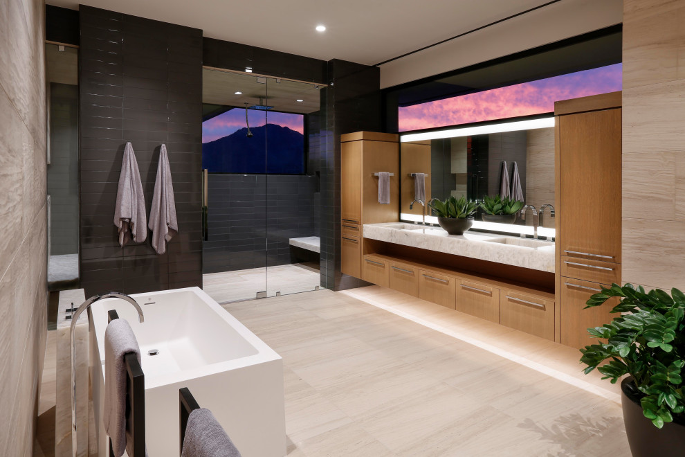 Photo of a contemporary master bathroom in Phoenix with flat-panel cabinets, light wood cabinets, a freestanding tub, ceramic tile, limestone floors, an integrated sink, engineered quartz benchtops, a hinged shower door, white benchtops, a double vanity, a floating vanity, a curbless shower and black tile.