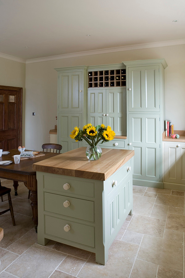This is an example of a country kitchen in Other with beaded inset cabinets and wood benchtops.