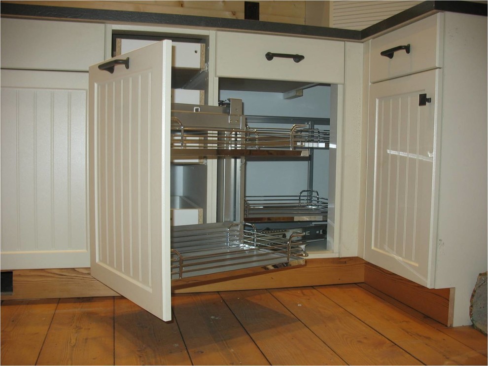 Example of a mid-sized mountain style l-shaped medium tone wood floor kitchen design with shaker cabinets, stainless steel appliances and an island