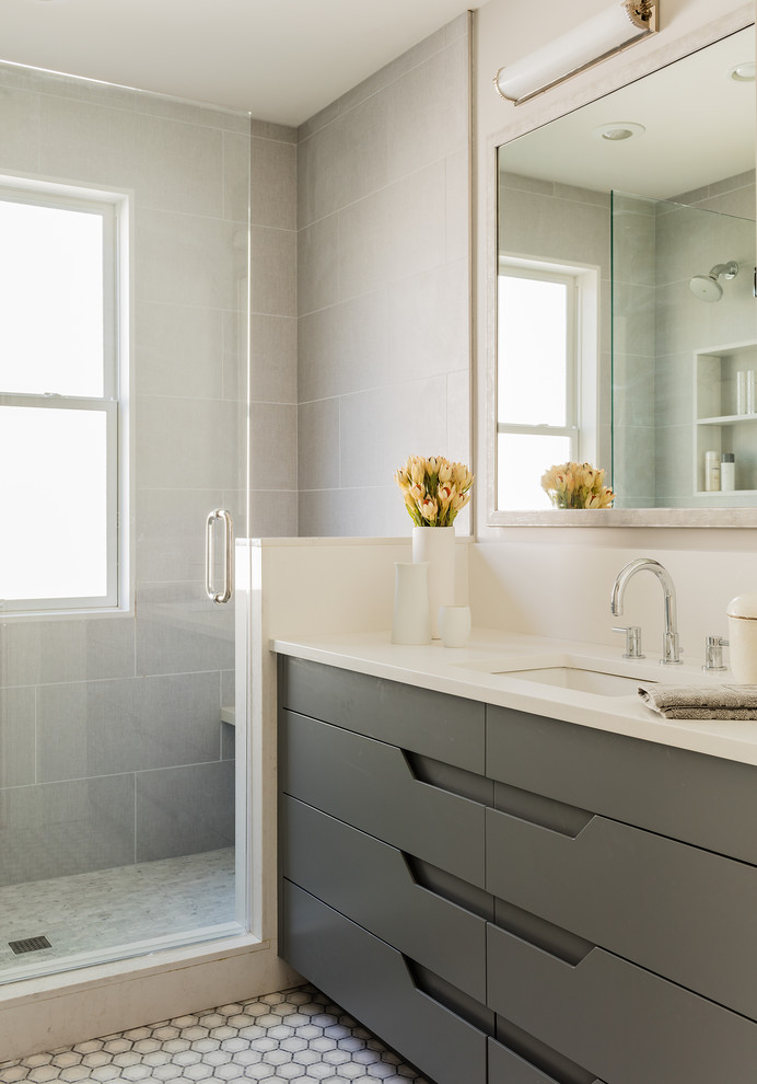 Inspiration for a mid-sized transitional master bathroom in Boston with an undermount sink, flat-panel cabinets, grey cabinets, engineered quartz benchtops, an alcove shower, a one-piece toilet, gray tile, porcelain tile, grey walls and porcelain floors.