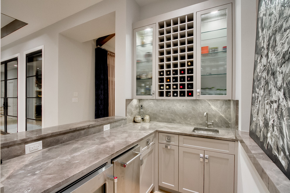 Design ideas for an u-shaped wet bar in Dallas with an undermount sink, shaker cabinets, beige cabinets, grey splashback, marble splashback and grey benchtop.
