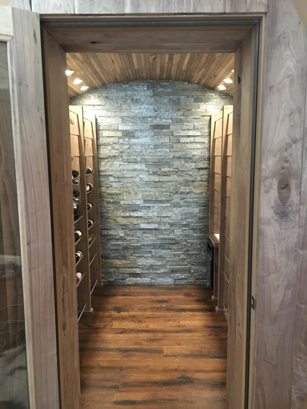 Inspiration for a mid-sized country wine cellar in Atlanta with dark hardwood floors, display racks and brown floor.