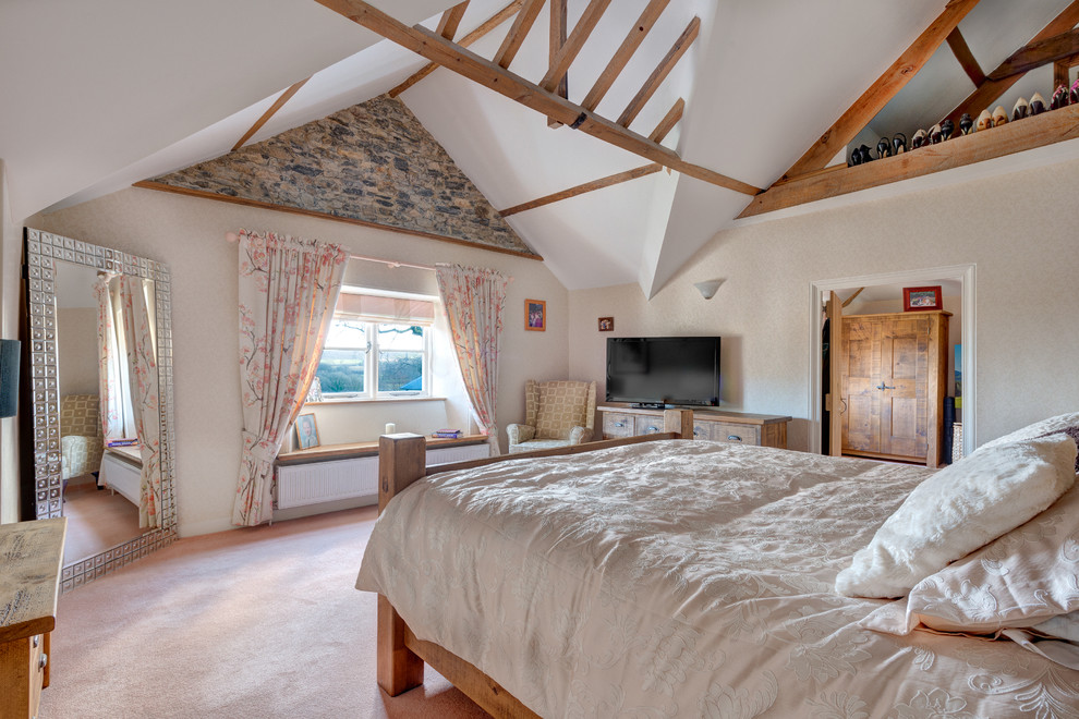 Country bedroom in Devon with beige walls and carpet.